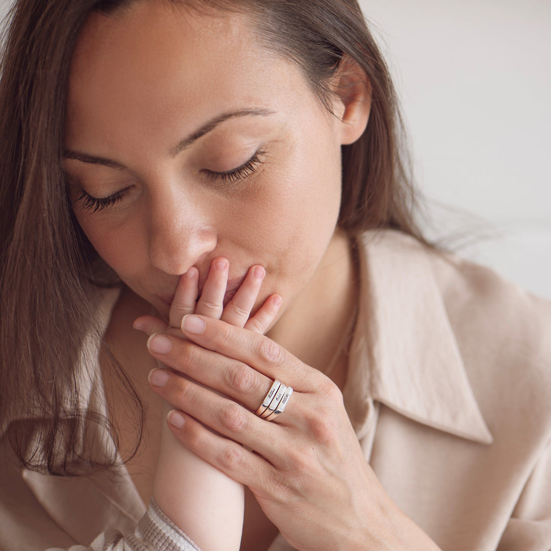 אישה עונדת טבעות חלב אם ומנשקת תינוק