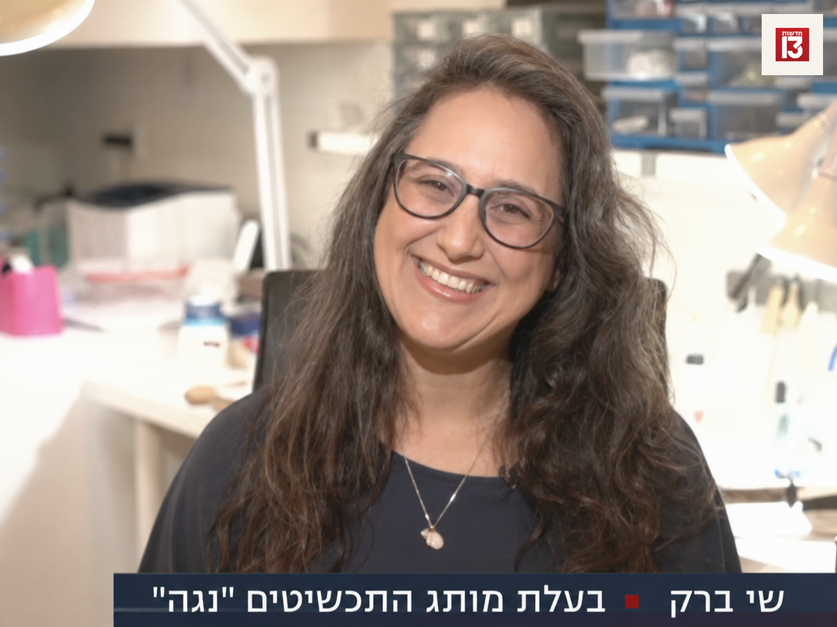 שי ברק, בעלת מותג התכשיטים נגה, מחייכת בסטודיו לעבודת יד