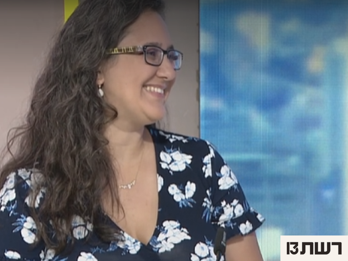 אישה מחייכת עונדת שרשרת זהב עדינה עם קריסטל